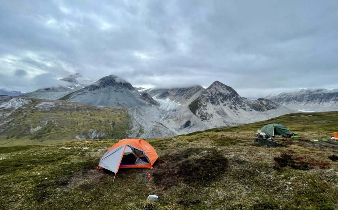 Samuel Glacier in the background with an orange tent set up for sleeping