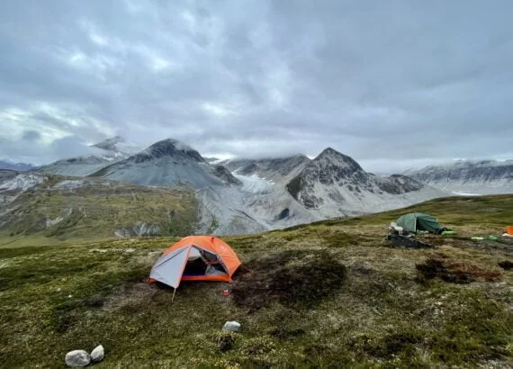 Samuel Glacier in the background with an orange tent set up for sleeping