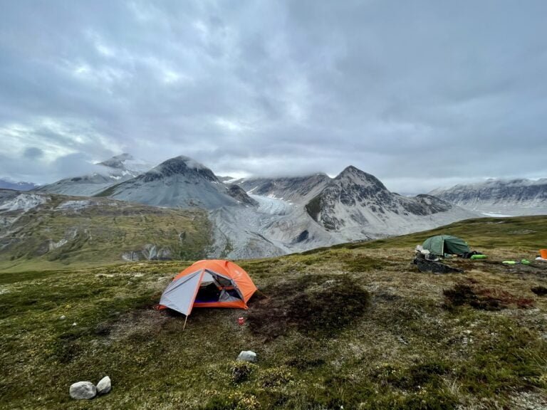 Samuel Glacier in the background with an orange tent set up for sleeping