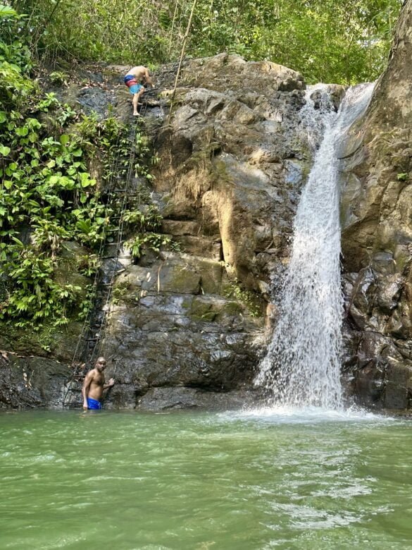 Arujan climbing up the ladder of Uvita Waterfall