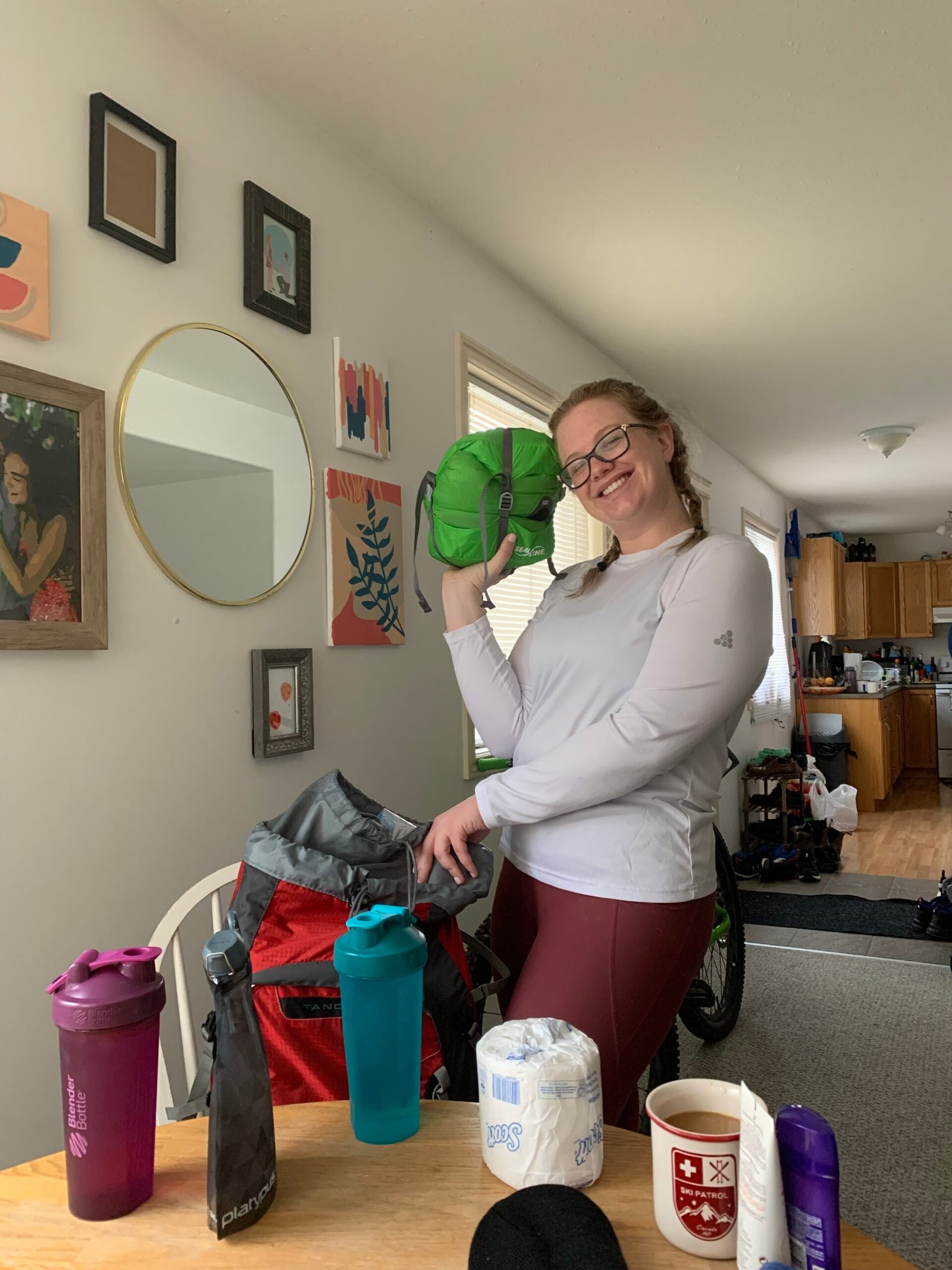 Posing with a green bag, packing for a hike