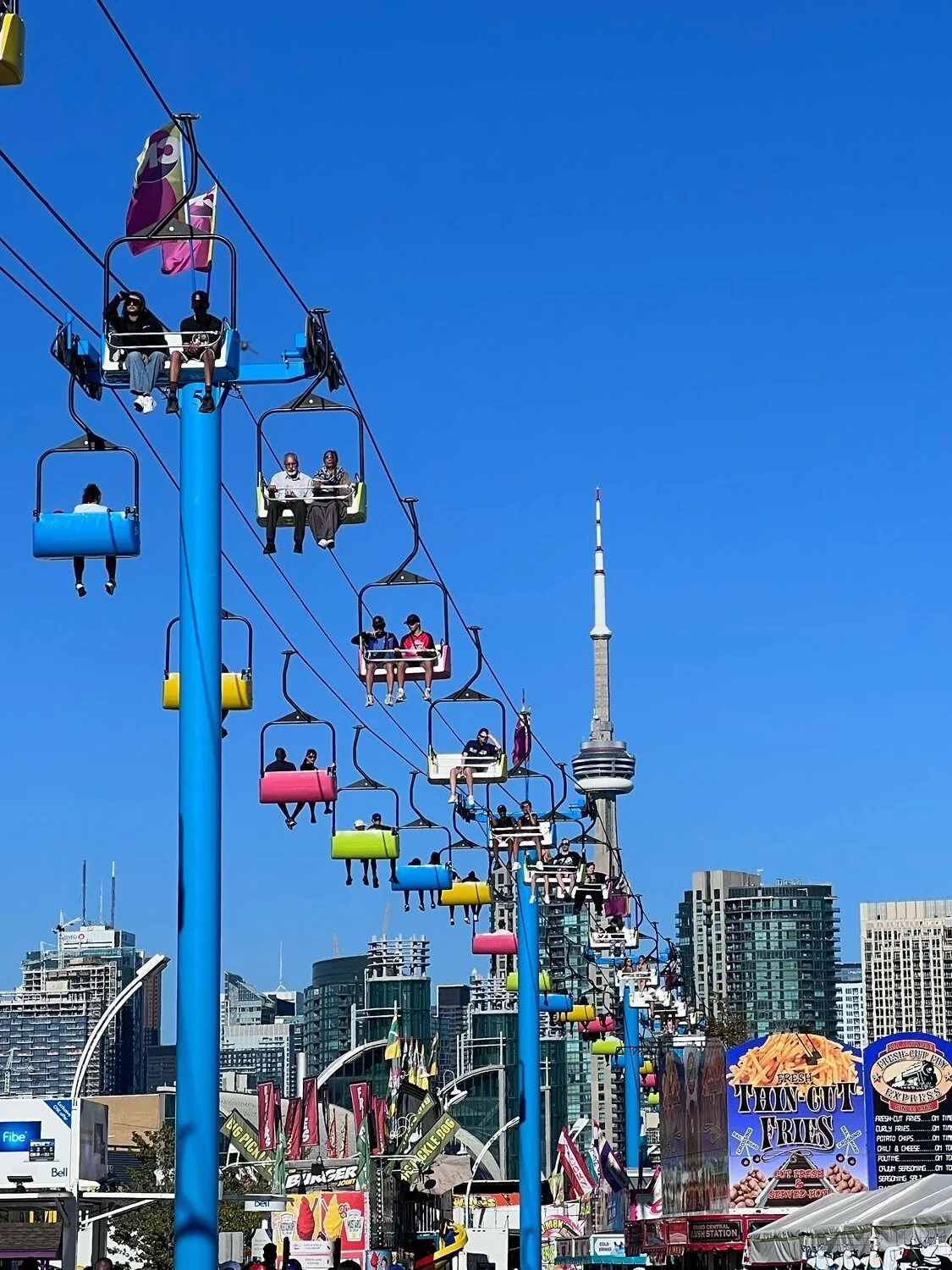 Rides at the CNE on Toronto Labour Day and the CN Tower in the background